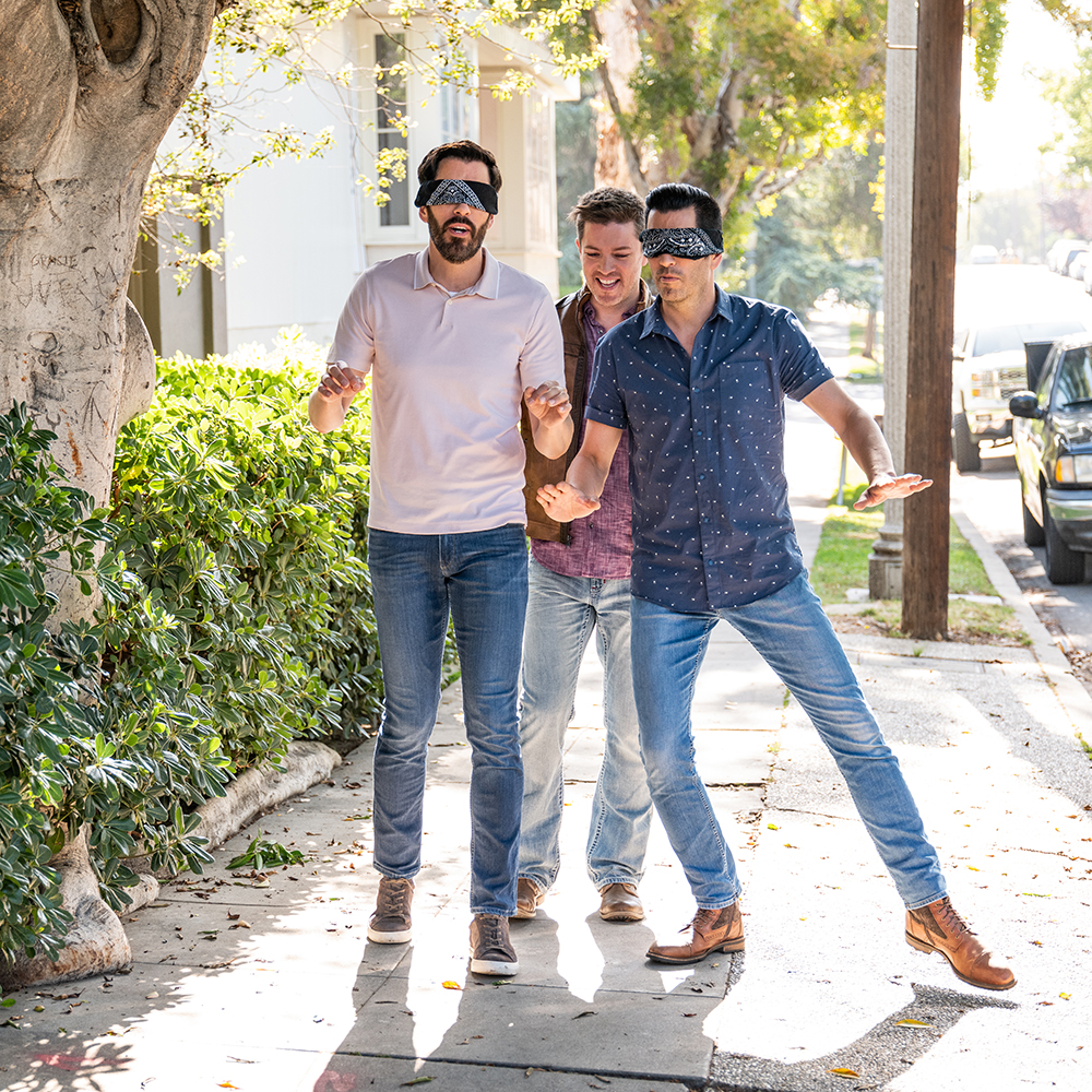 JD walks Drew and Jonathan Scott down the street while they wear blindfolds.