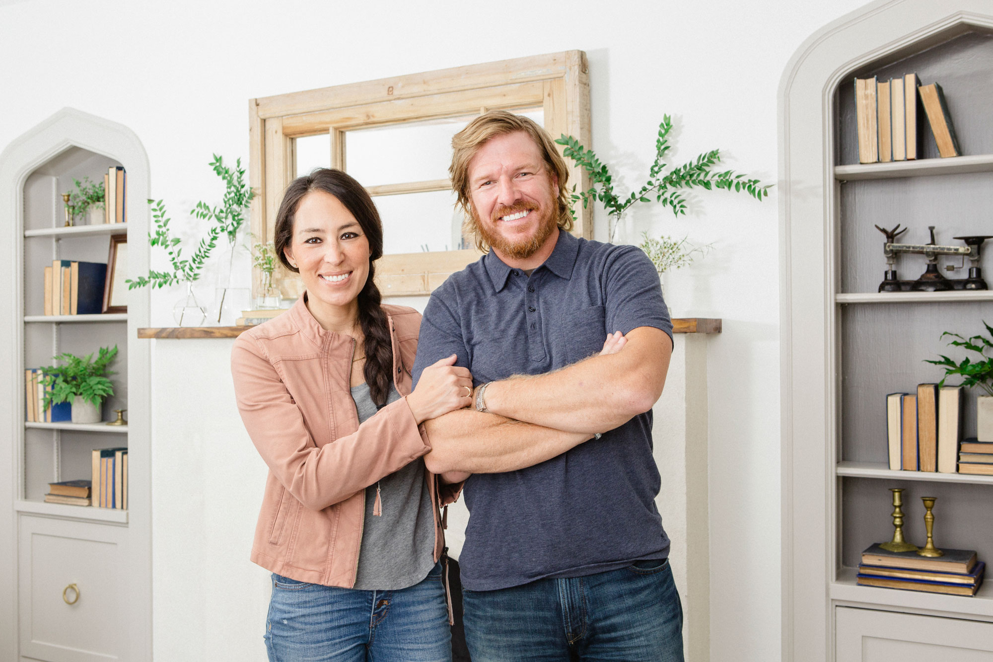 Chip and Joanna Gaines posing for a photo in front of a fireplace.