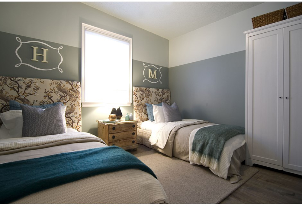 grey room with two beds with floral headboards