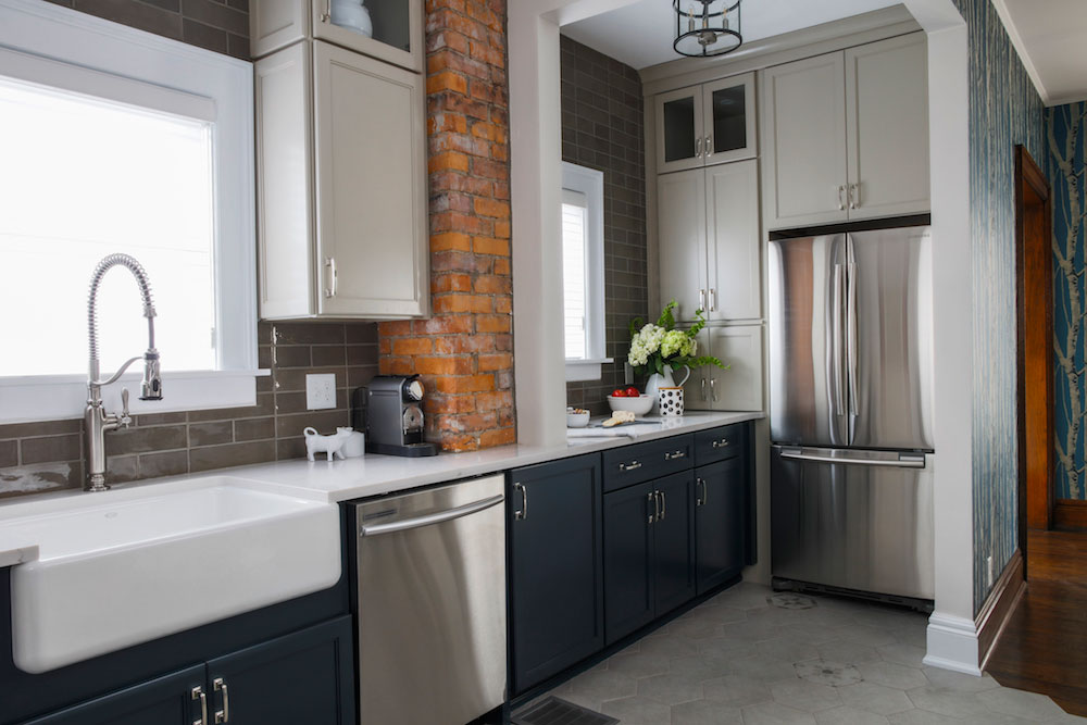 rustic kitchen with grey subway tile, brick and two-tone cabinets