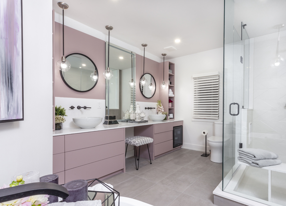 lavender bathroom with white double sinks and black-framed mirrors