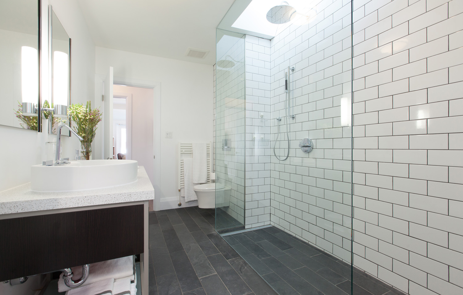 modern bathroom with white subway-tile shower and grey tiled floor