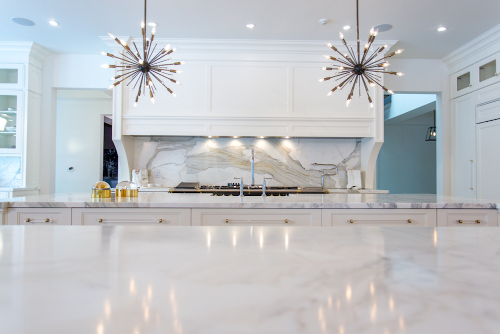 white and marble kitchen with white hood range