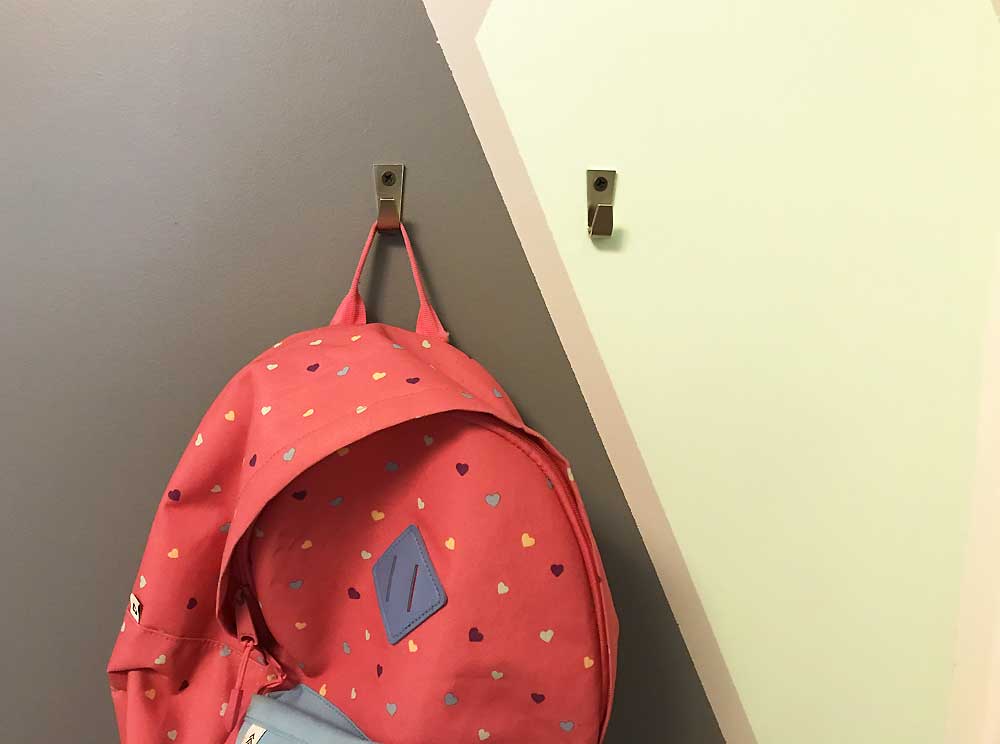 pink patterned backpack hanging on colorblocked wall