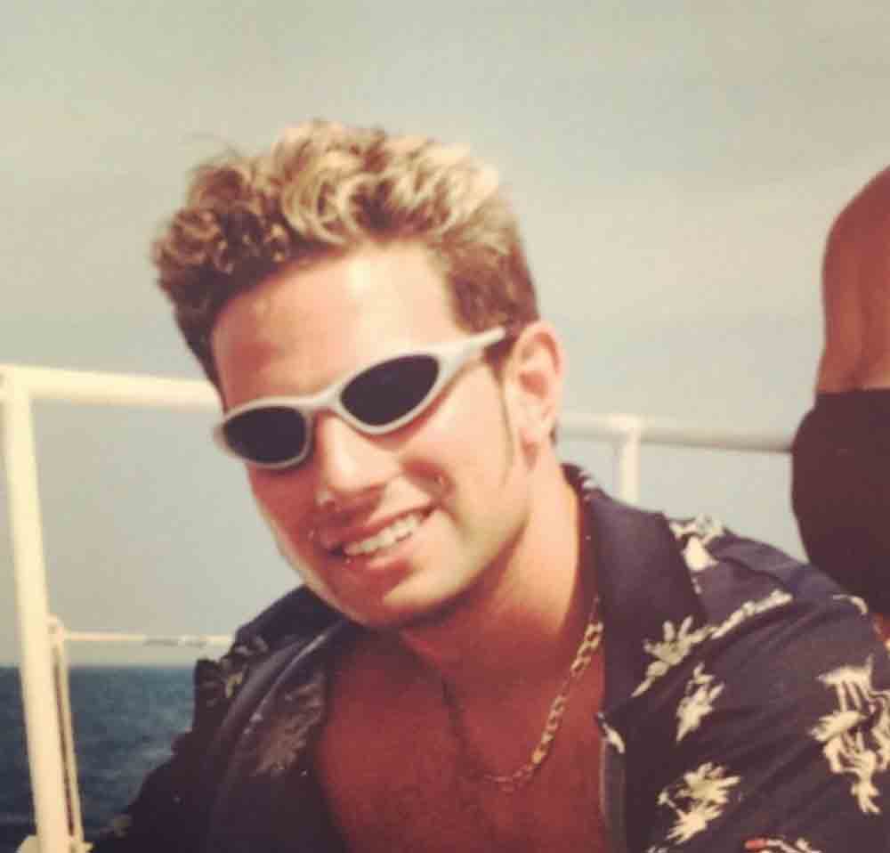 Scott McGillivray with blonde hair wearing a Hawaiian printed shirt.