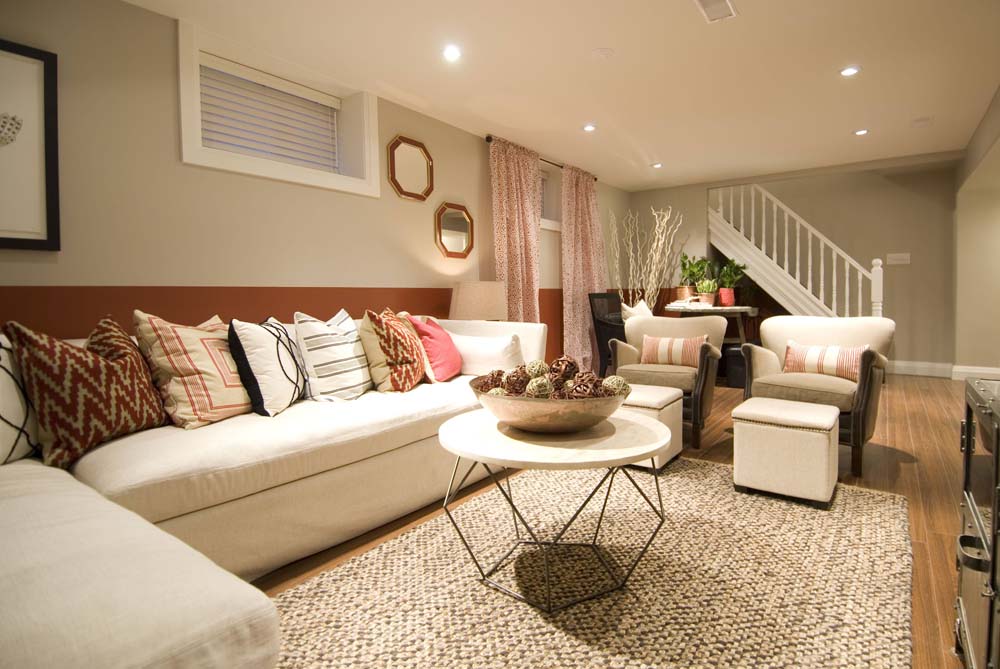 Beautiful finished basement feature large sectional couch and seating area with geometric accents.