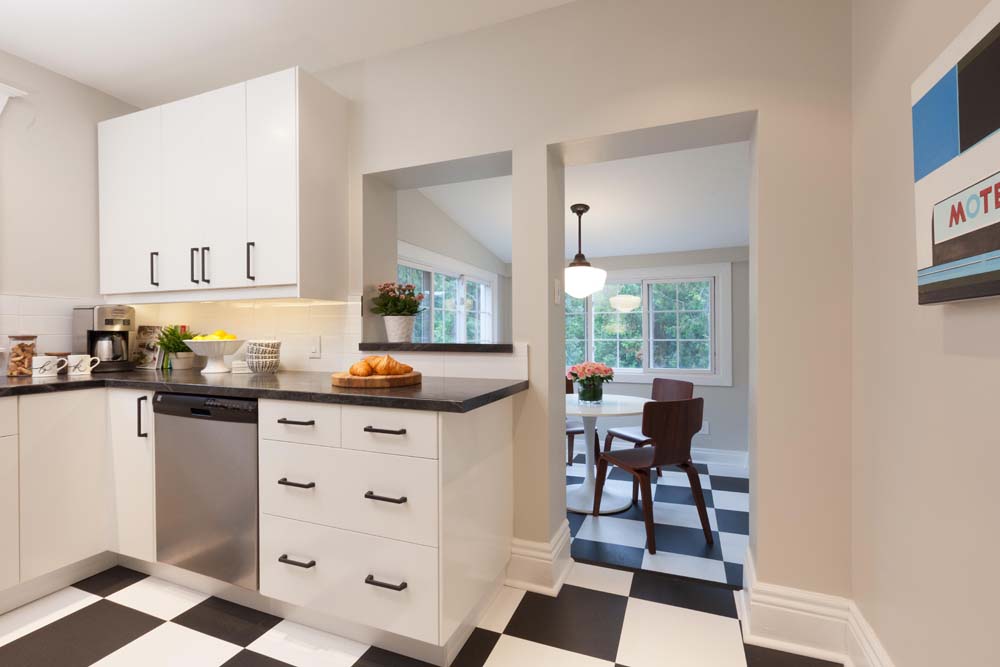 Kitchen featuring white cabinets and black hardware, with white and black check tiled flooring.
