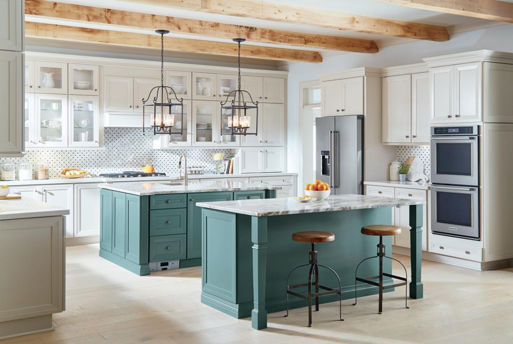 Large neutral kitchen that with two prominent islands in teal and stone.