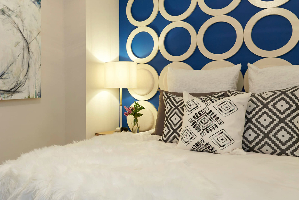 Bright blue wall and custom design found in bedroom.