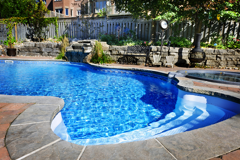 Beautiful big and blue pool, surrounded by custom stone details and a contemporary stone wall.