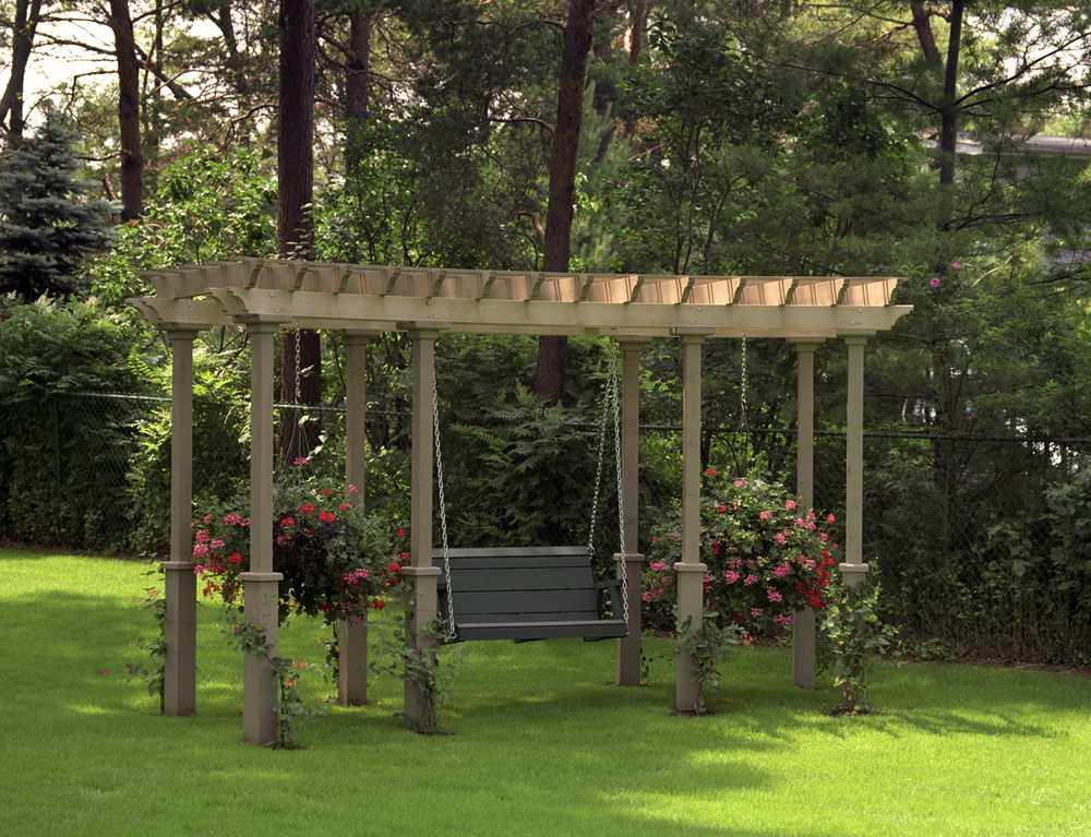 A big sized pergola with a swing, featuring beautiful red and pink flowered planters on each side of swing.