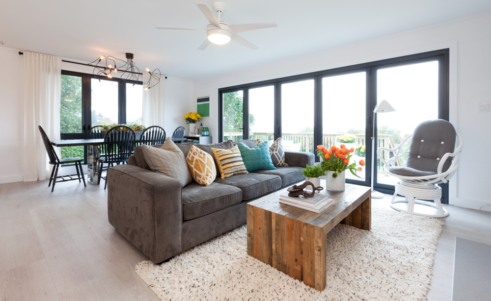 Large windows with lots of natural light coming into open concept living room layout.