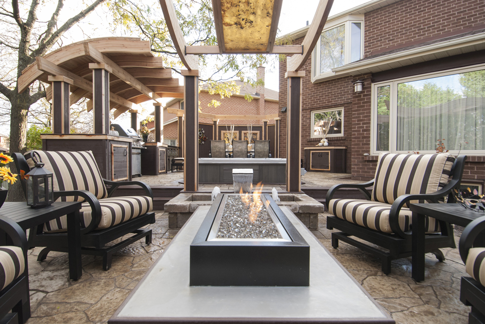 Outdoor kitchen and barbeque set up, with cozy sitting area and fire pit.