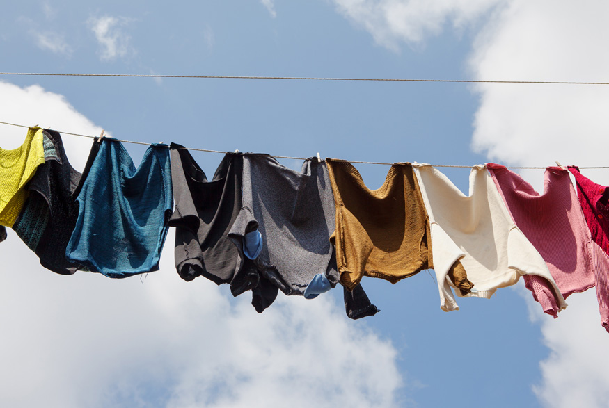 Multi-coloured clothing hanging outside on a laundry line