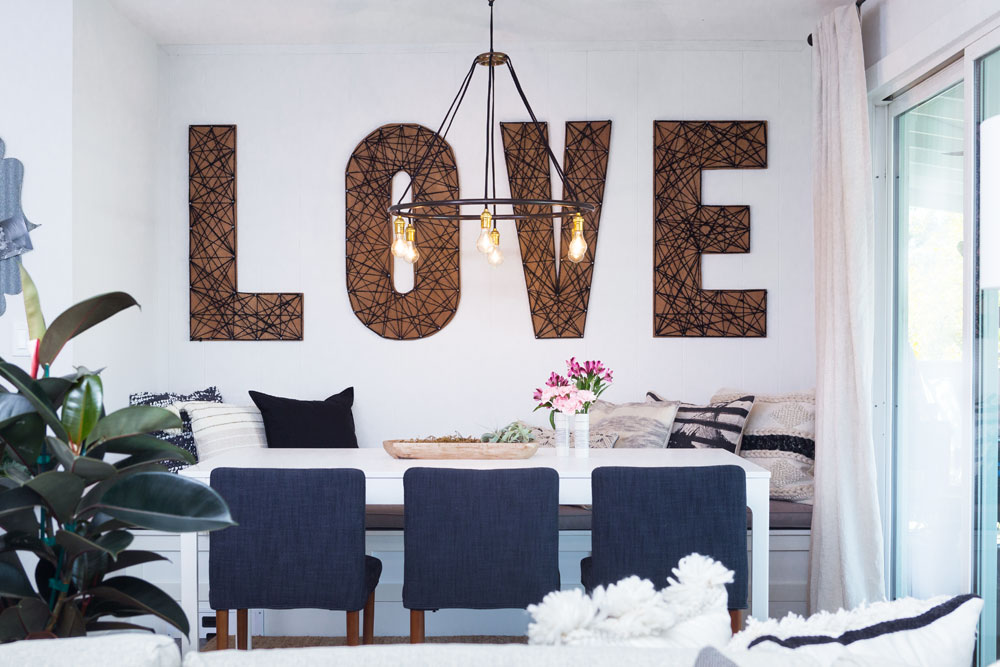 Cozy banquette with oversized letter wall art that spells 'love'