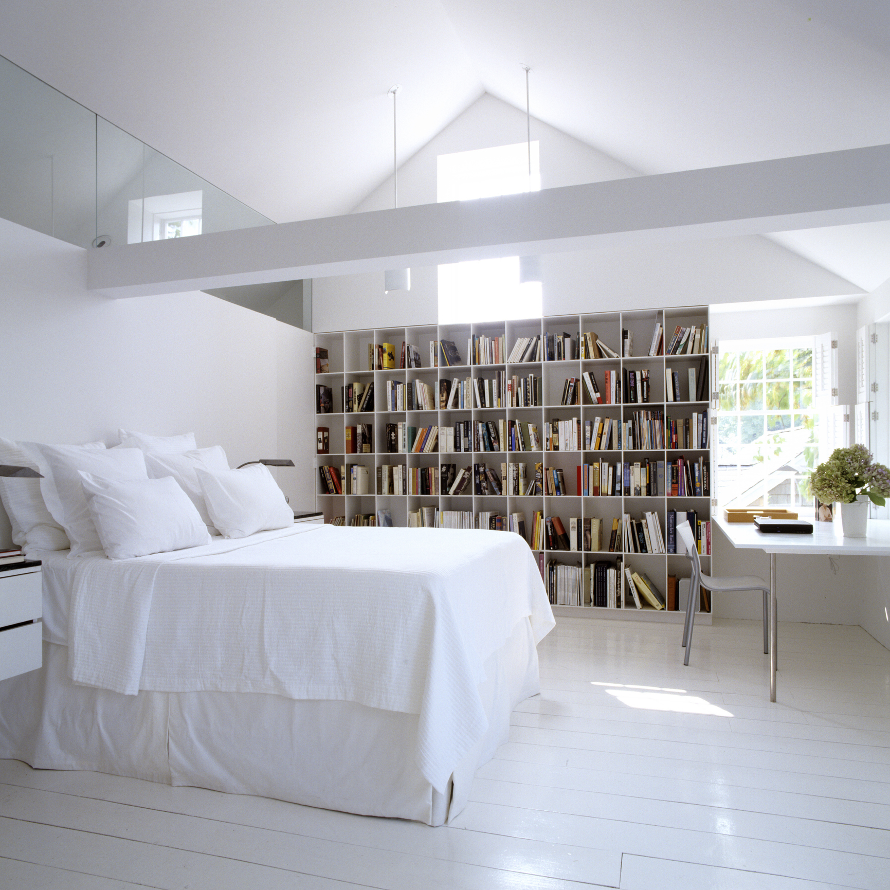 All-white library in farmhouse with peaked roofline