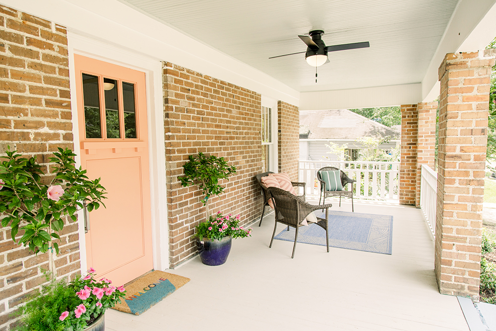 A front porch with a coral-peach front door and porch
