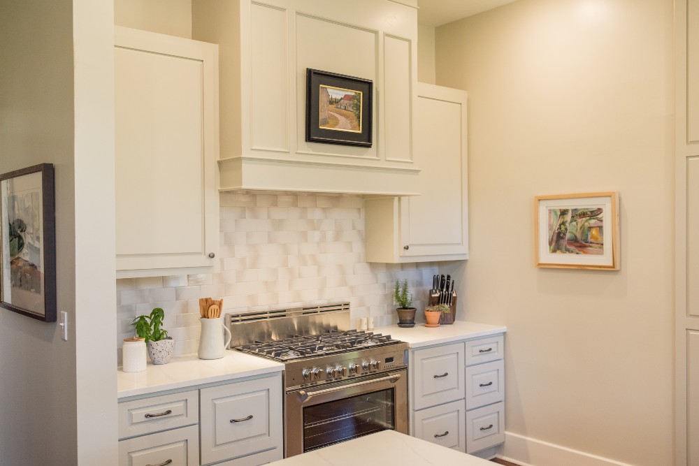 A cream white kitchen with ombre tile backsplash
