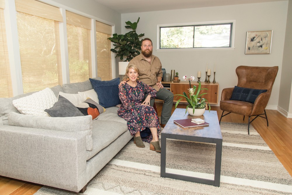 Ben and Erin Napier sitting in mid century modern living room