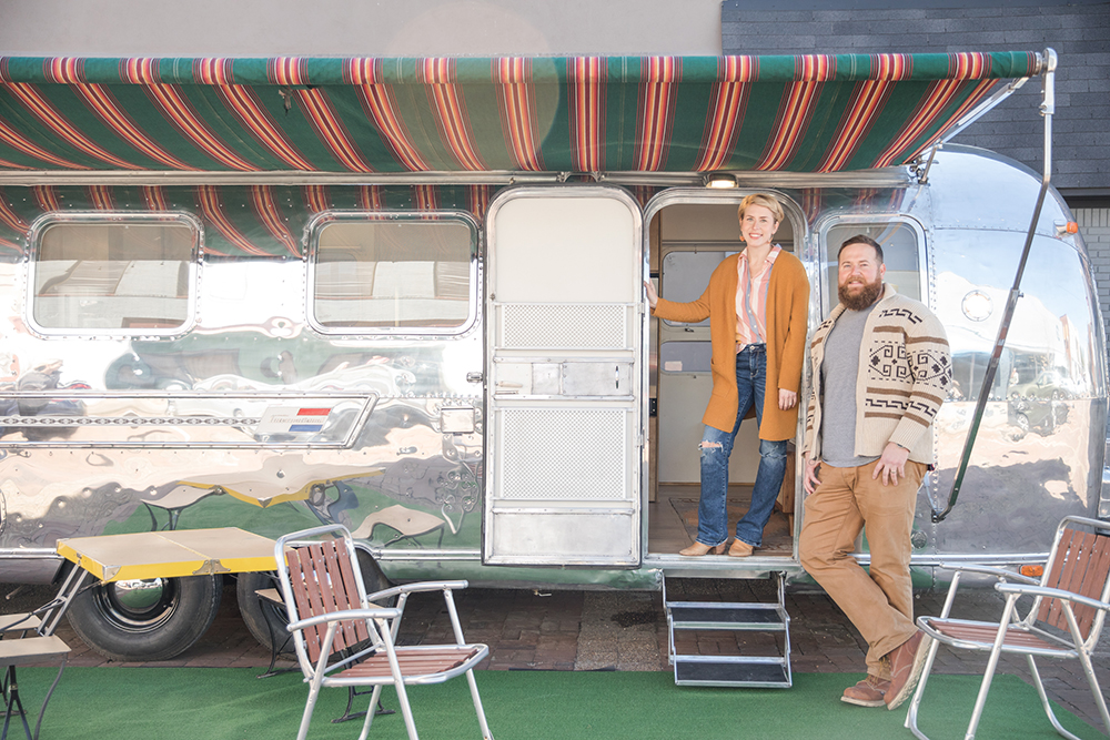 Ben and Erin Napier standing next to silver Airstream