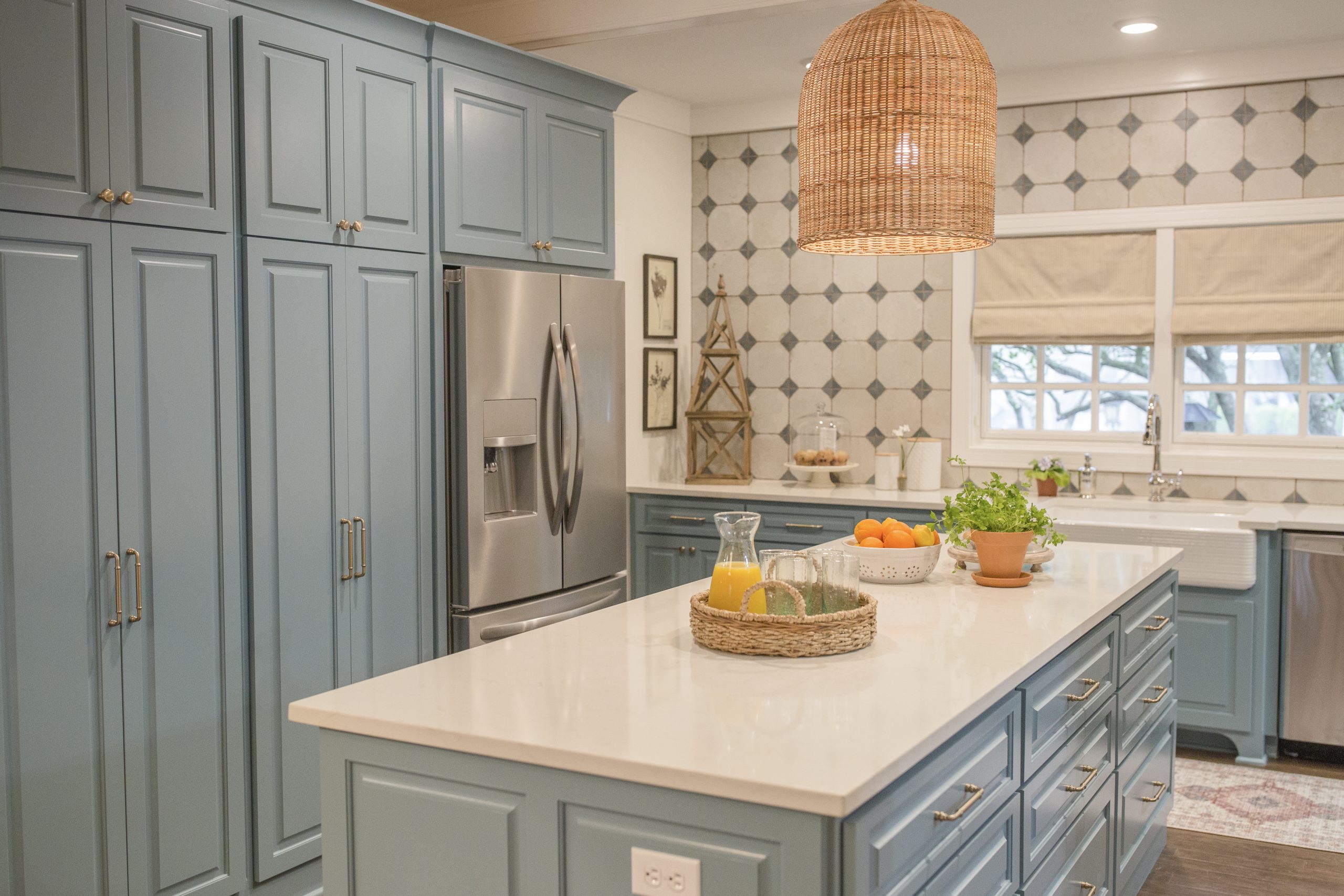 A kitchen with blue cabinetry and a unique blue diamond pattern backsplash