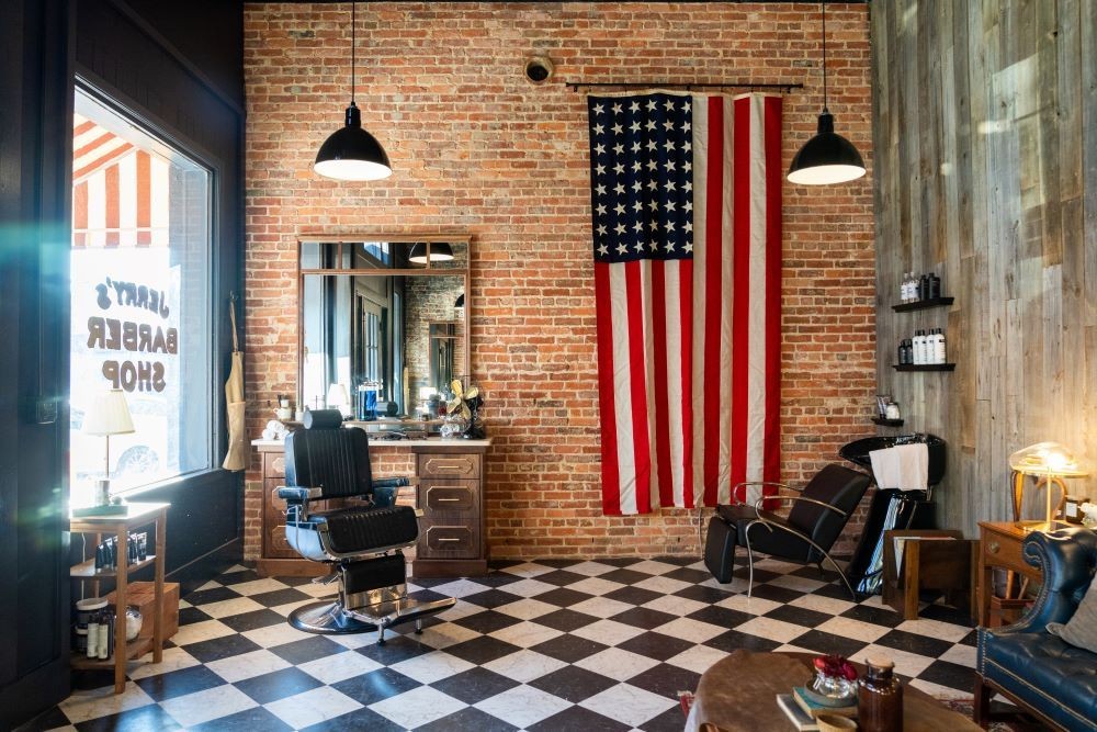 Stylish barbershop interior with brick walls and USA flag hanging on wall