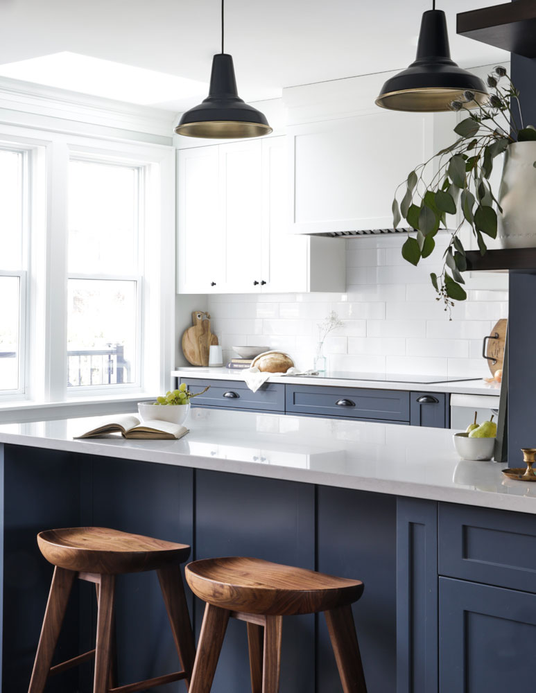 Modern and rustic kitchen with white upper cabinets and navy blue lowers.