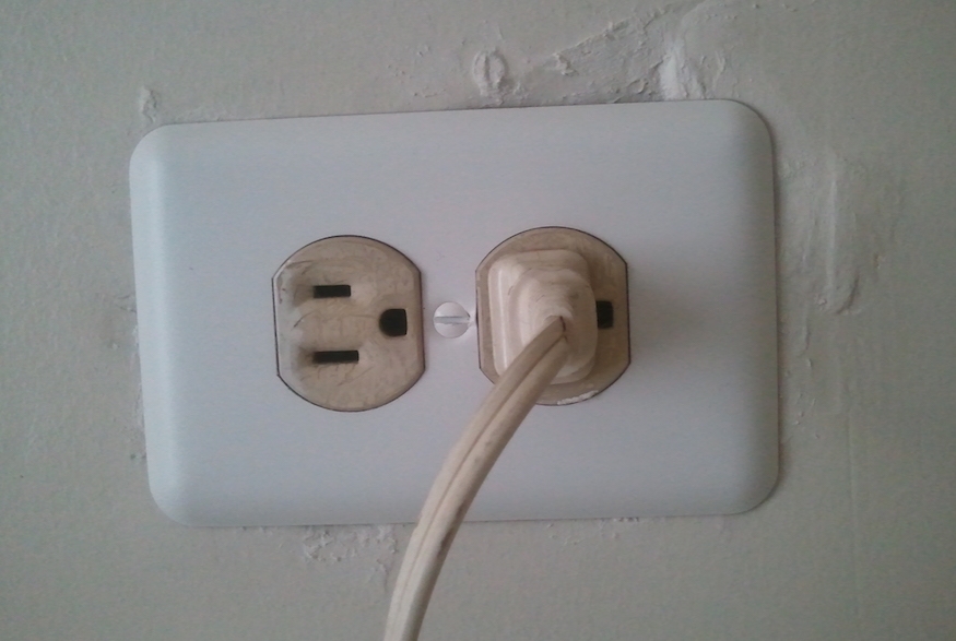 Plug and electrical outlet on wall