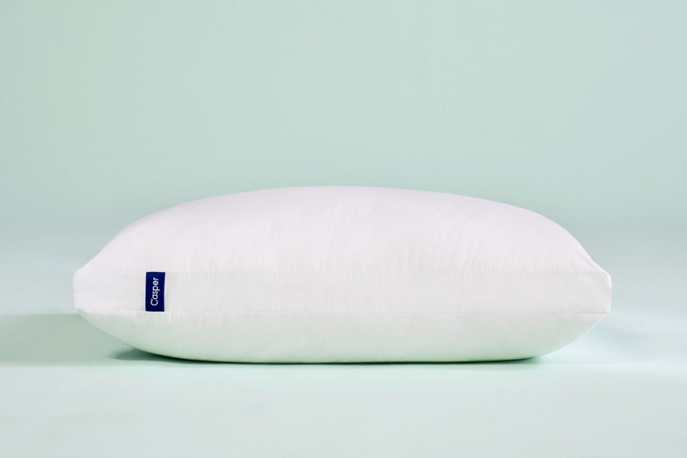 A Casper pillow in a mint blue background.