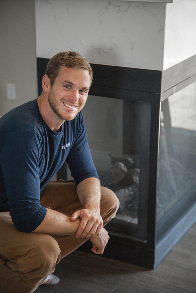 Mike Holmes Jr. in front of fireplace