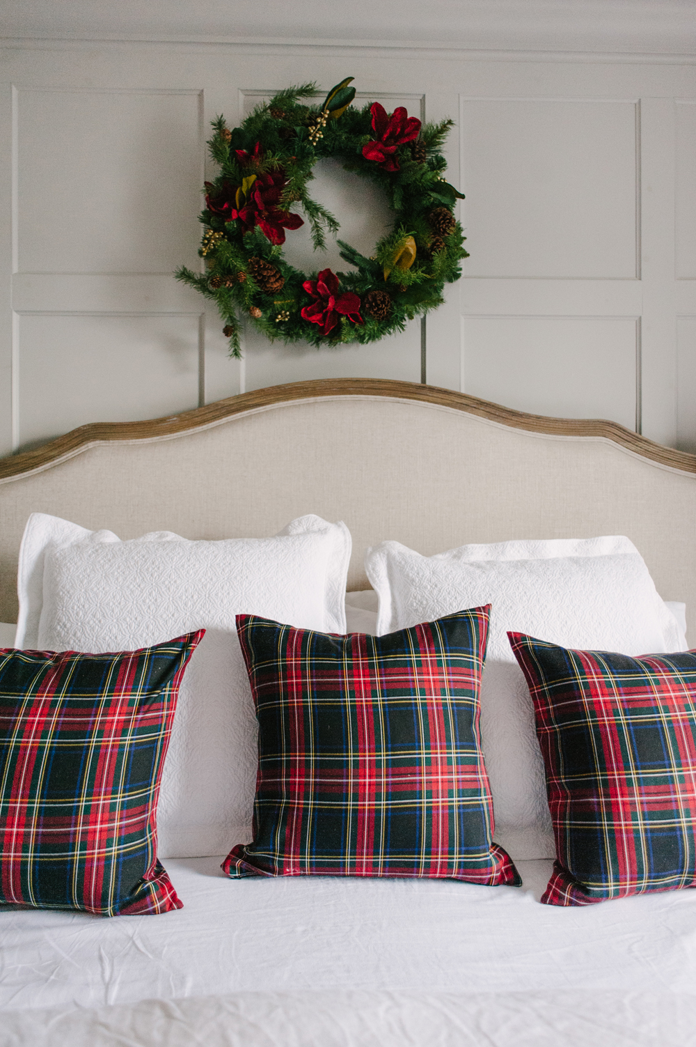 Three plaid pillows arranged on a cozy bed