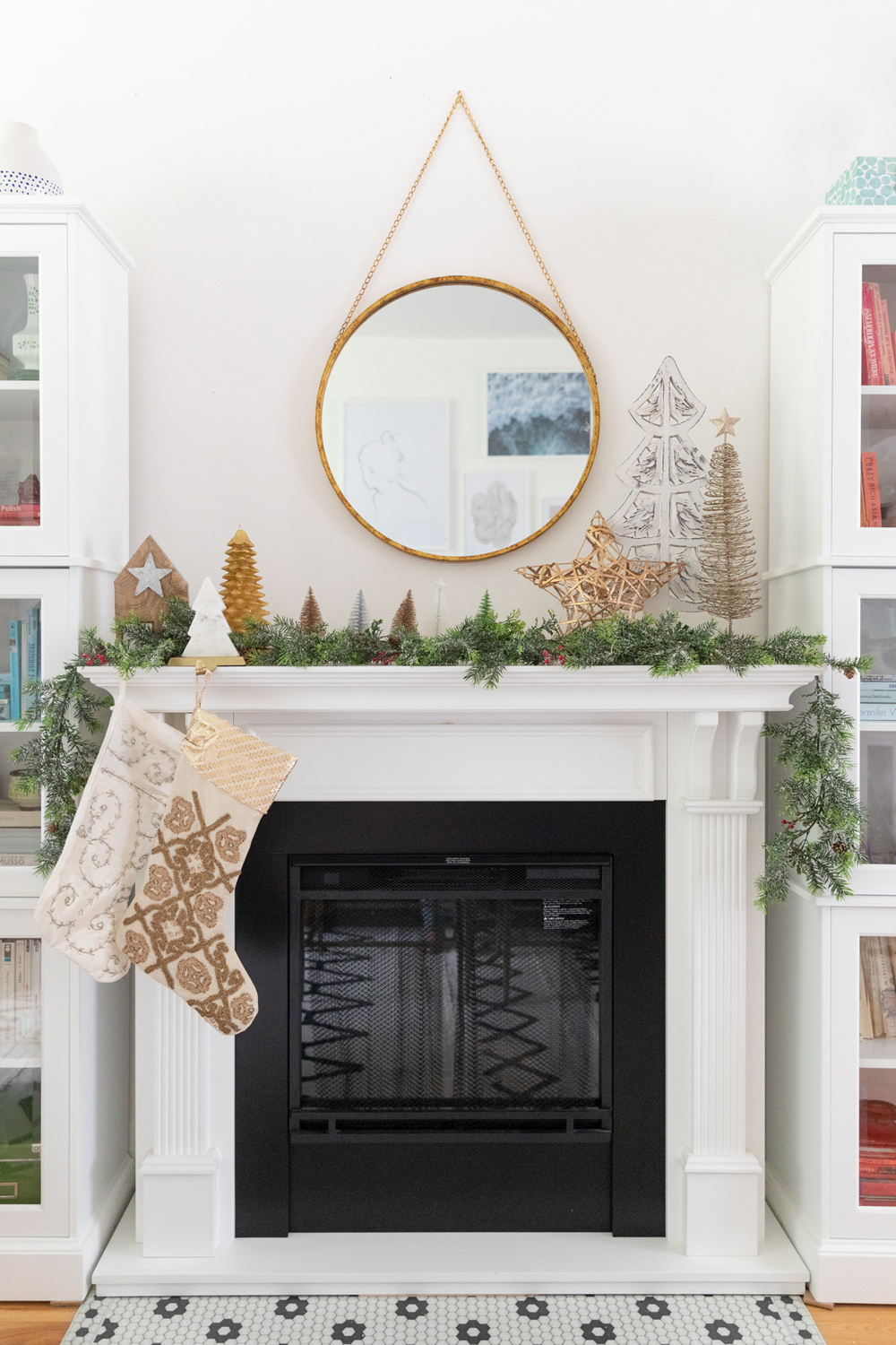 A gas fireplace decorated with Christmas decor, including stockings