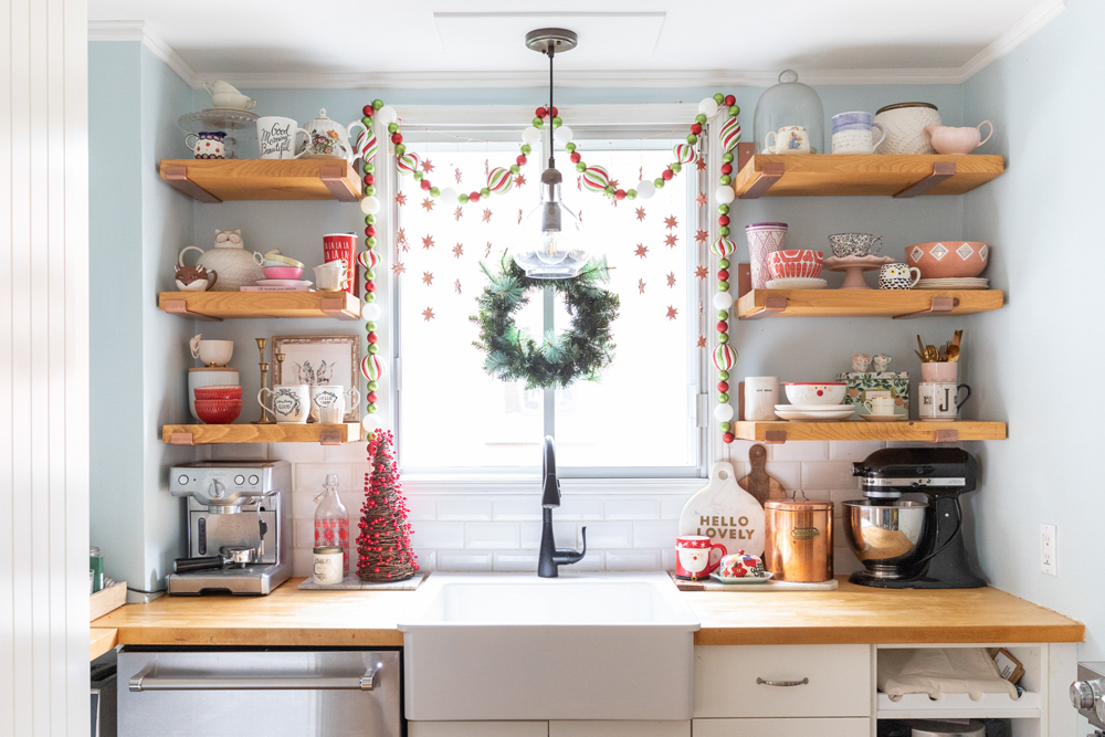 Bright holiday-themed kitchen window above the sink overlooking the property