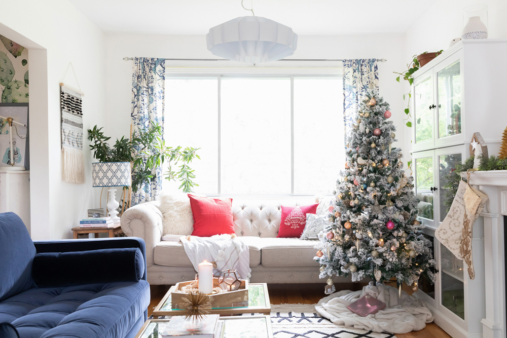 A brightly lit living room with a decorated Christmas tree in the right-hand corner