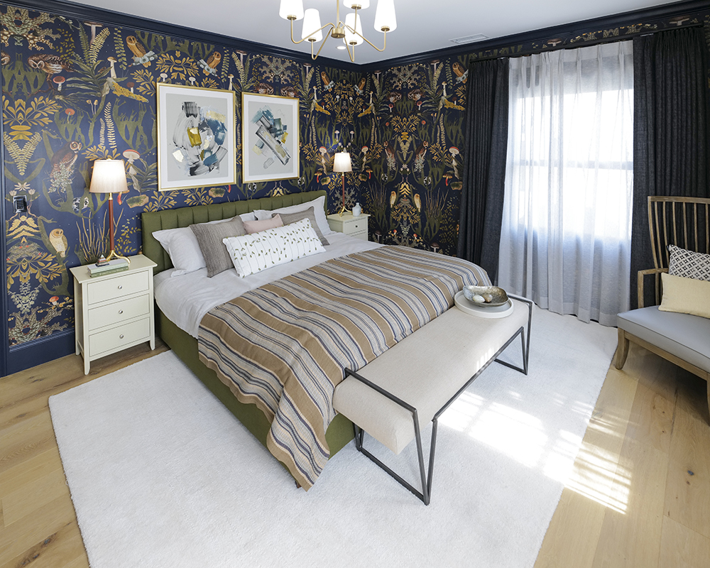 A bedroom with decorative wallpaper and custom art