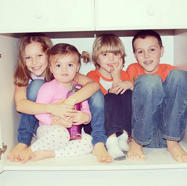 Sarah and Bryan Baeumler's kids pose inside a kitchen cupboard