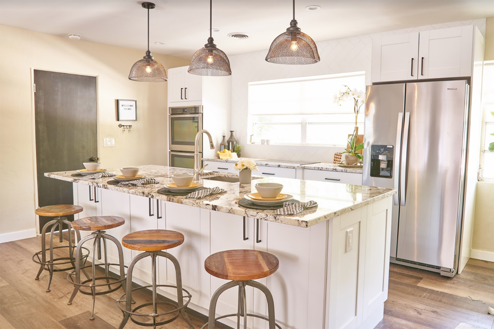Kitchen with island, pendant lighting and wood stools