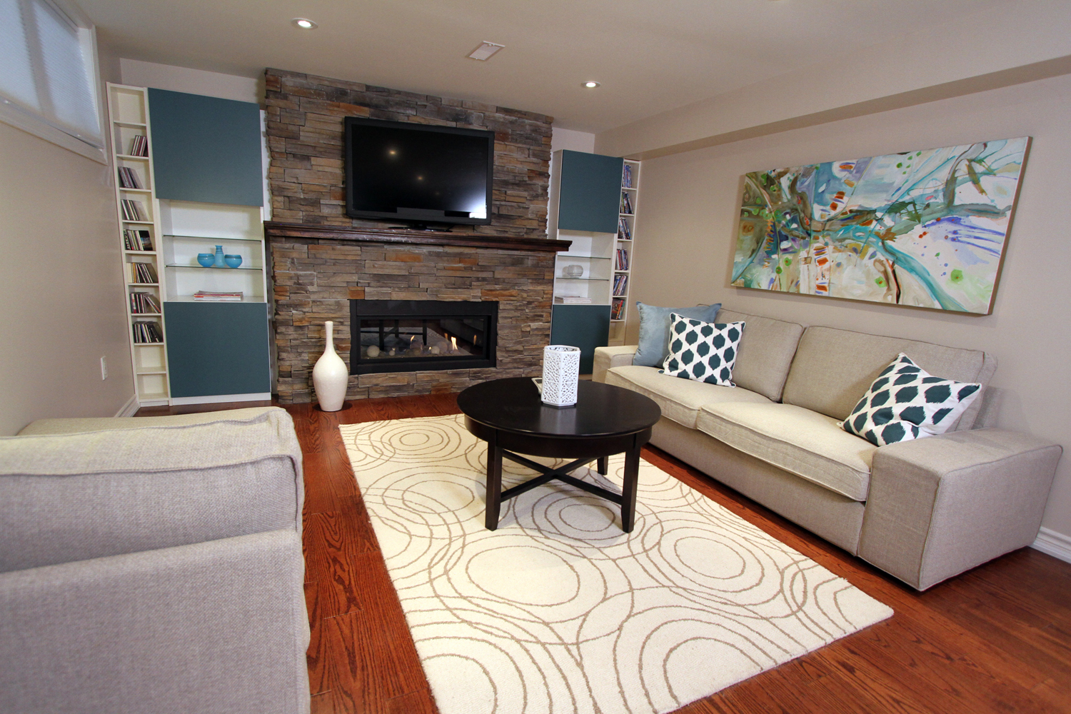 Living room basement with a fireplace and television
