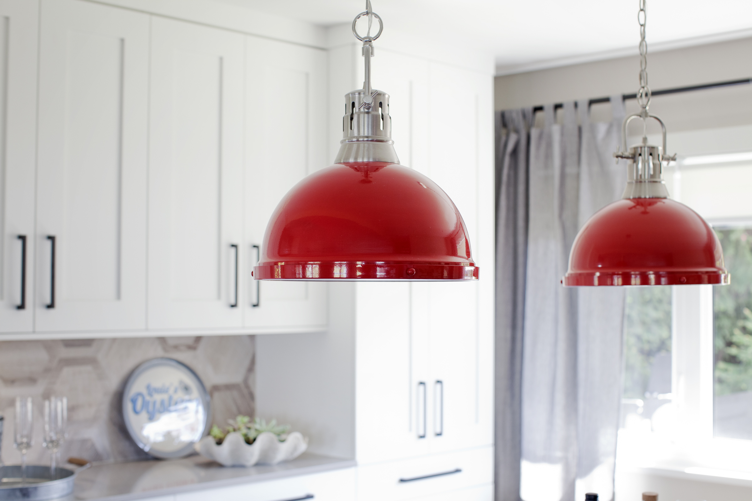 Modern kitchen with red pendant lights.