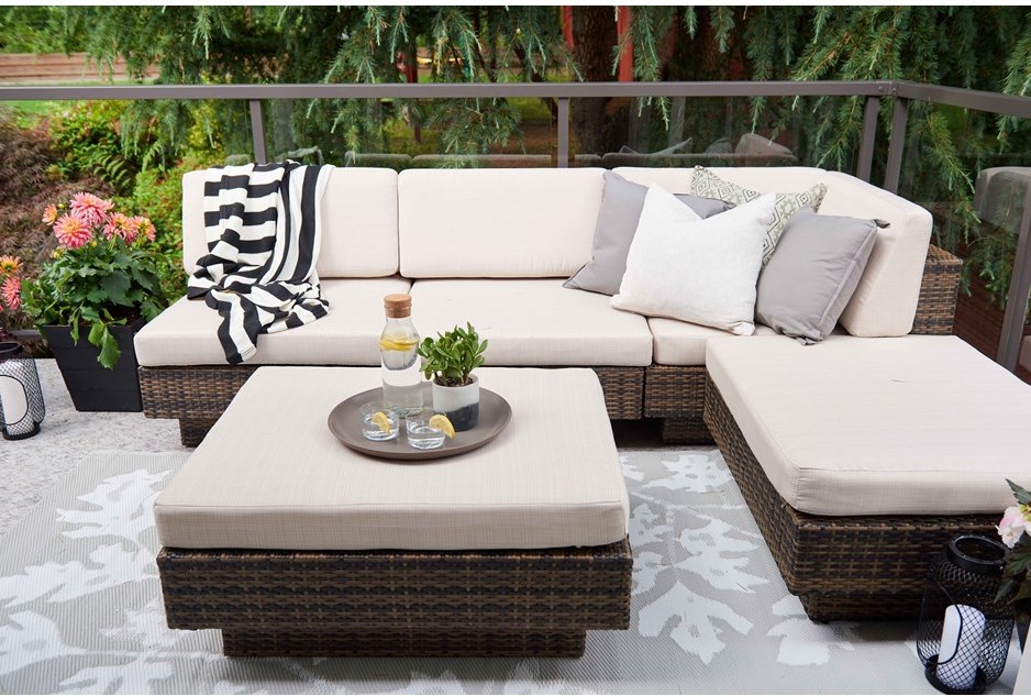 Cozy outdoor terrace with a patterned rug and cushions.