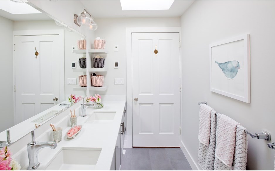 A dainty bathroom design with soft pink accents.