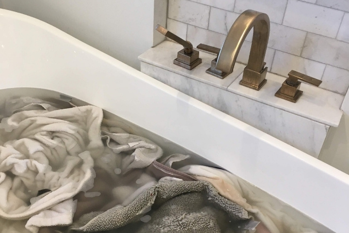 Laundry stripping towels in bathtub