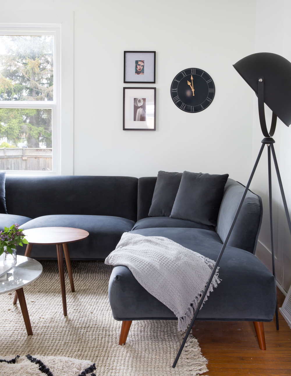 grey velvet sectional from short end with floor lamp in black foreground