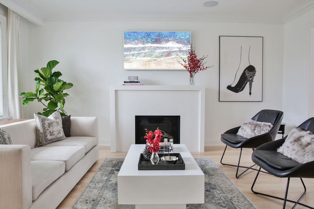 Sleek white living room with black chairs and fireplace
