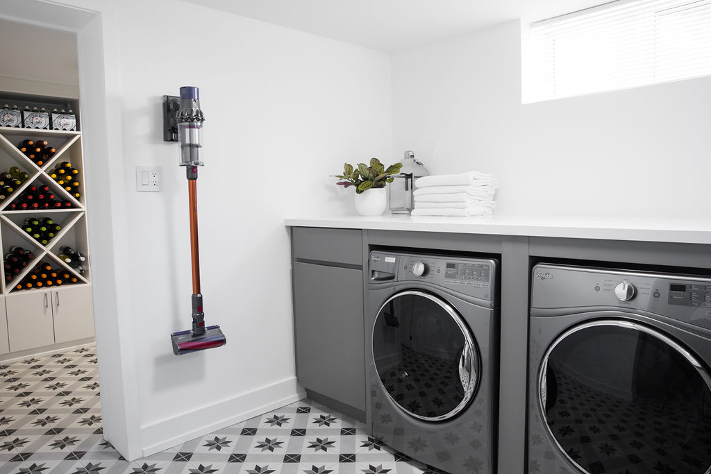 Sleek, tiled laundry room with wine rack off to the left-hand side