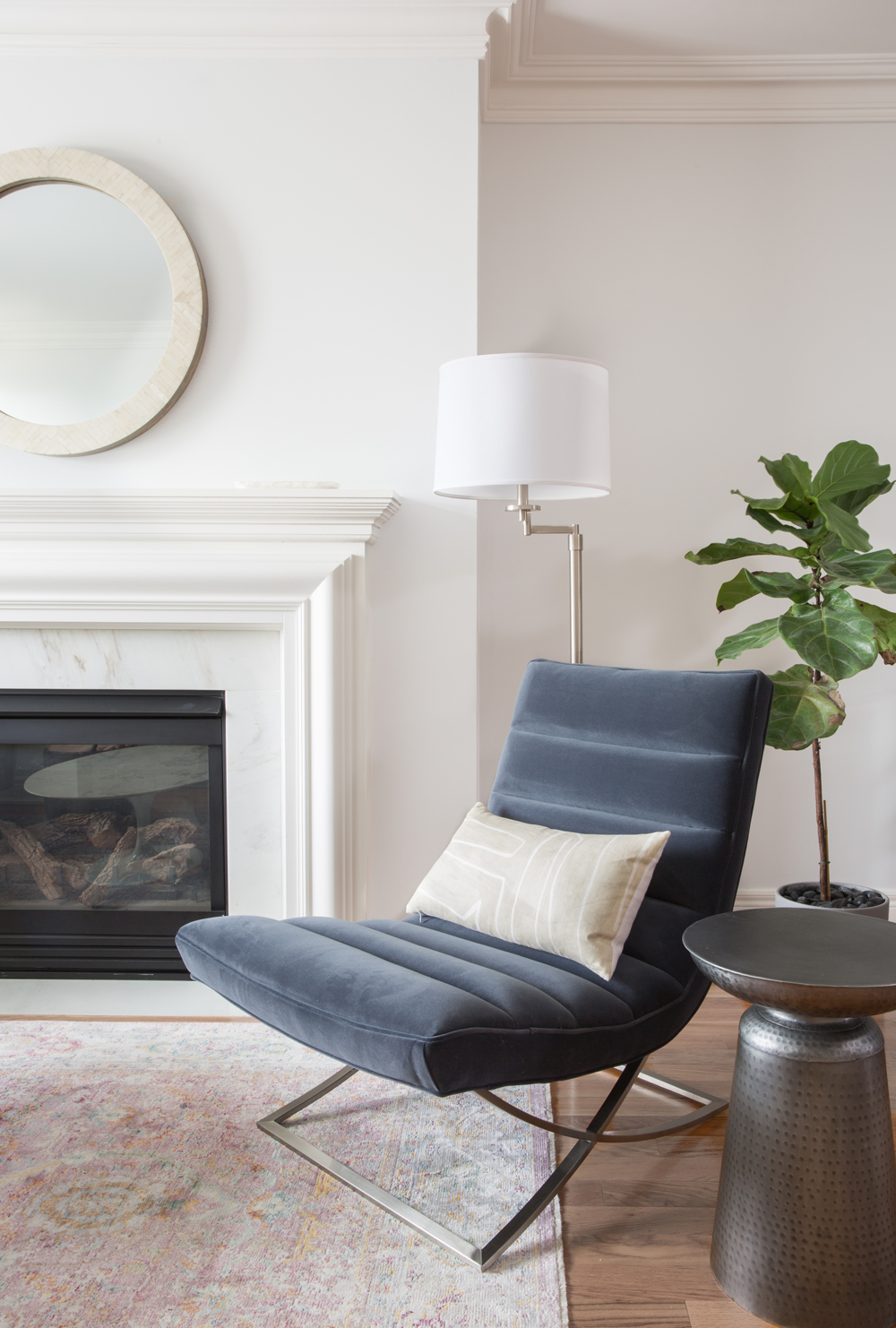 slate blue grey velvet arm-less chair with chrome base and tan rectangular cushion by fireplace