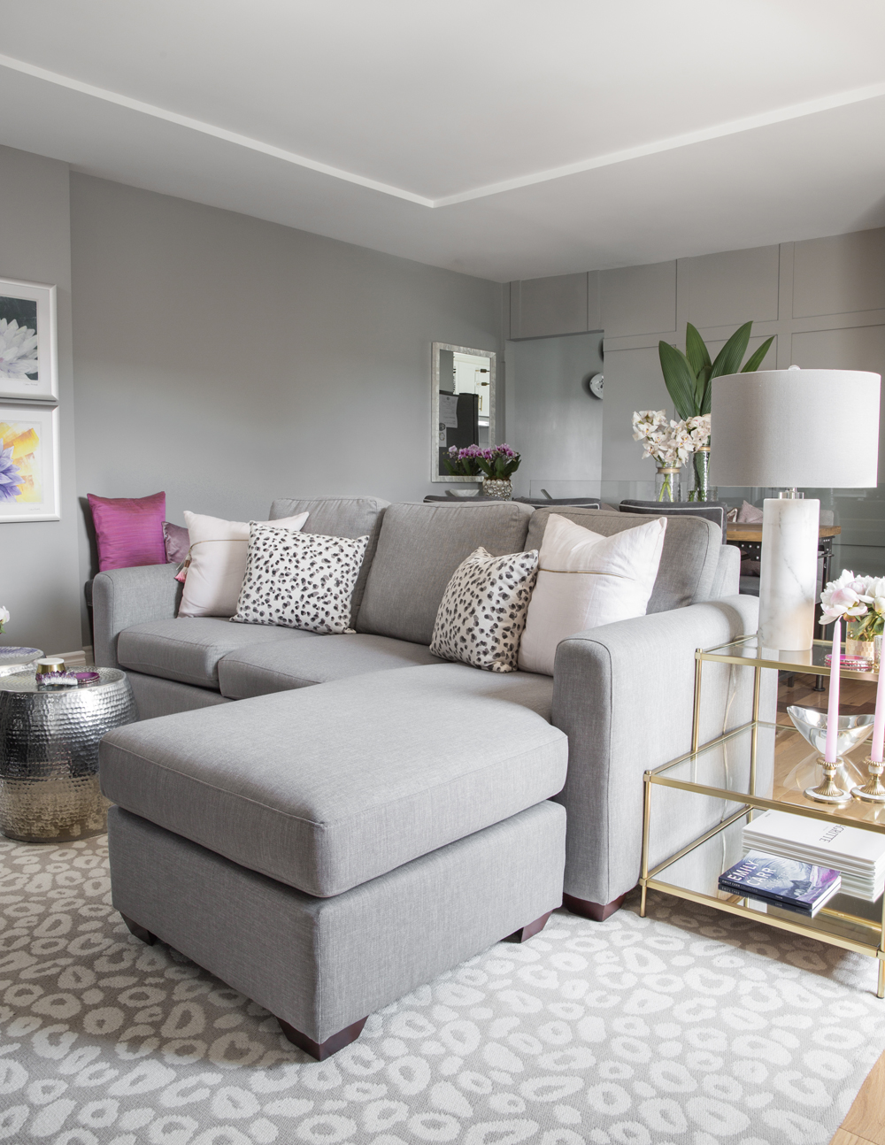 grey sectional with two white cushions and two spotted ones in grey living room