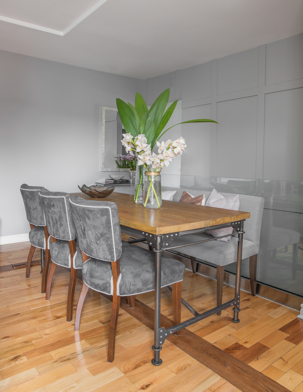 wood top dining table with metal legs in grey dining area with panelled wall