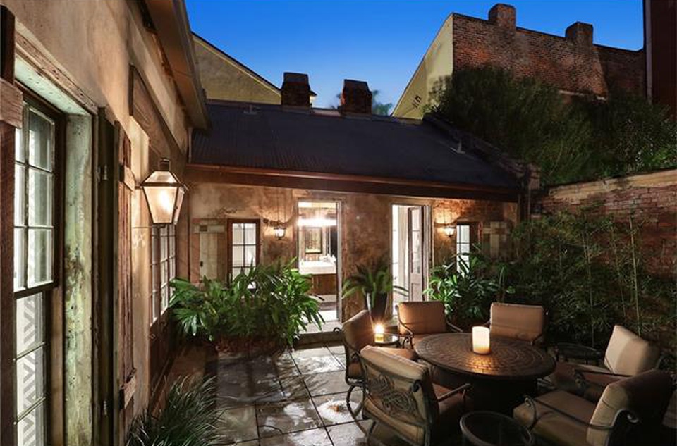 Private courtyard with patio furniture and surrounded by high brick wallks