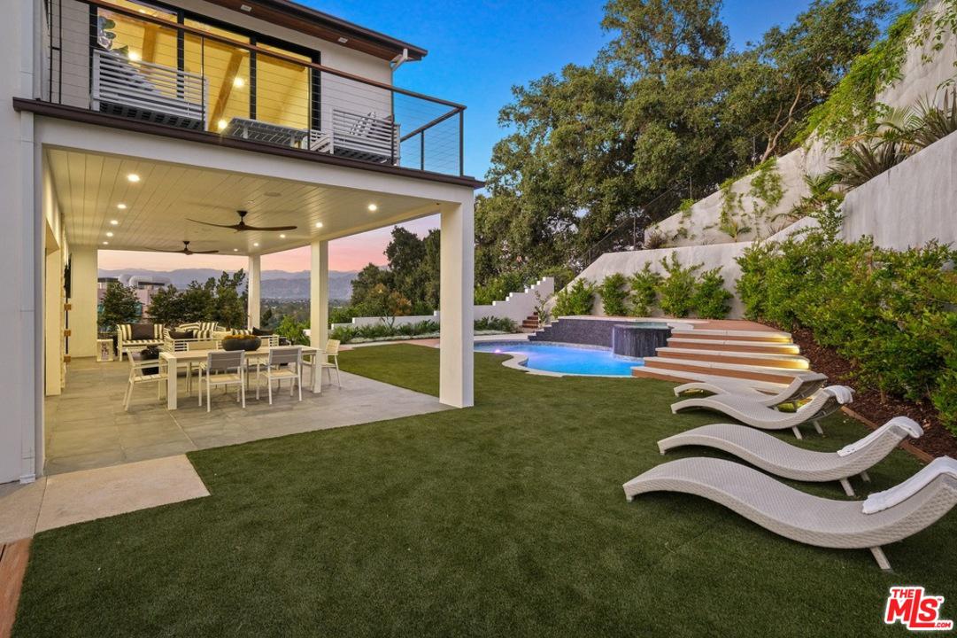 Backyard with covered area, lawn and pool